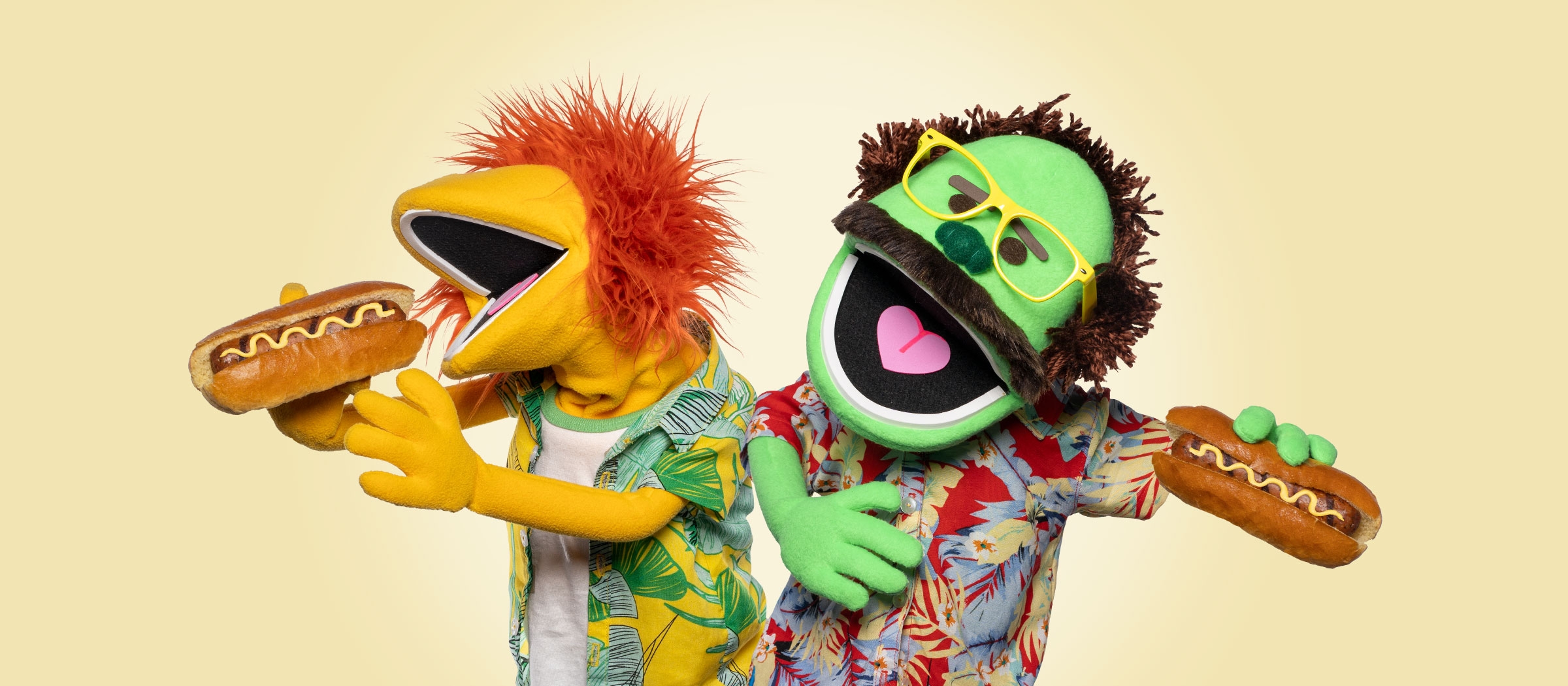  Image of two puppets holding Gilbert's sausages in buns 